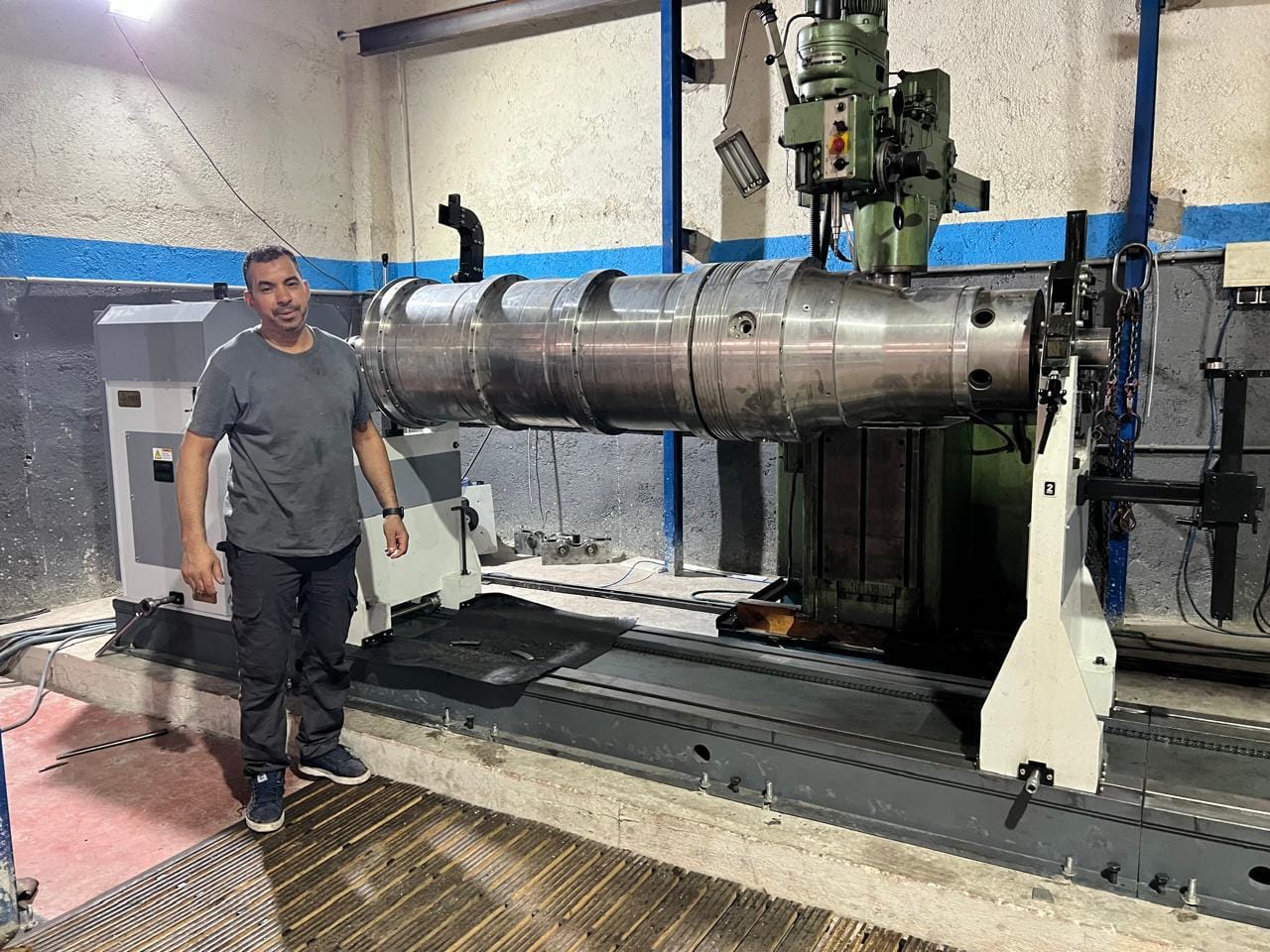 a man standing next to a machine - Maintenance Préventive